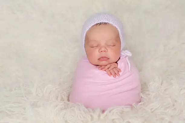 Photo of Newborn Baby Girl with Pink Bonnet and Swaddle