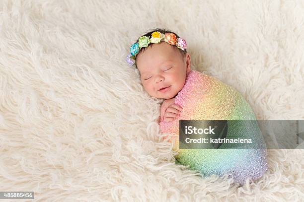 Smiling Newborn Baby Girl Wearing A Rainbow Colored Swaddle Stock Photo - Download Image Now