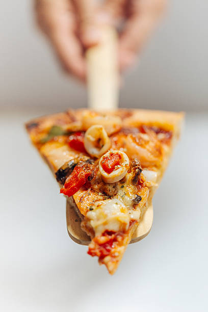 Slice of fresh homemade seafood pizza stock photo