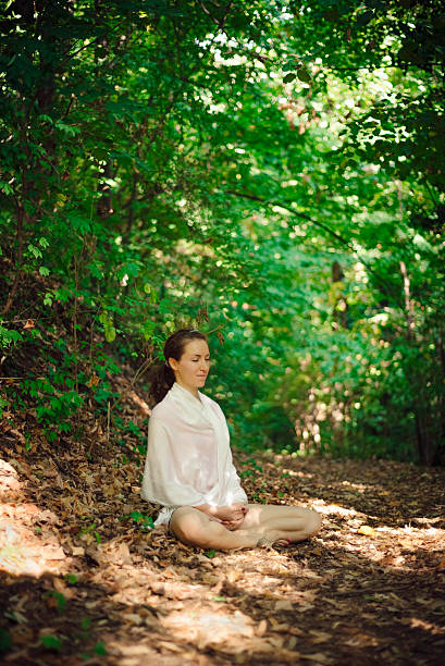 istock Young fit woman meditating in nature 485888320