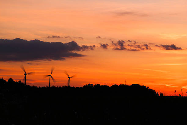 windmills in motion at sunrise sunset time. can be used for windmills, energy, nature, climate and environment themes