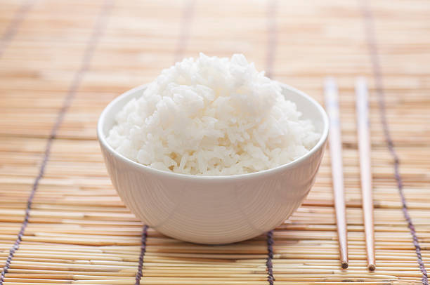 Rice bowl Rice bowl on bamboo mat with chopsticks rice bowl restaurant stock pictures, royalty-free photos & images