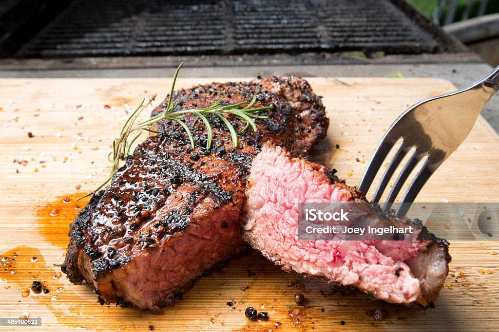 New York Steak Freshly cooked New York Strip garnished with fresh Rosemary. Strip Steak Stock Photo