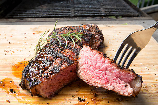 New York Steak Freshly cooked New York Strip garnished with fresh Rosemary. char grilled photos stock pictures, royalty-free photos & images
