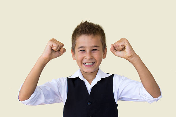 istock Little boy cheering his success in suit against colored backgrou 485904766