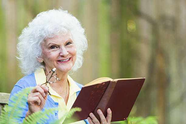 istock Senior woman with white hair reading book 485904978