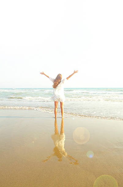 istock cheering woman open arms under sunrise on beach 485908126