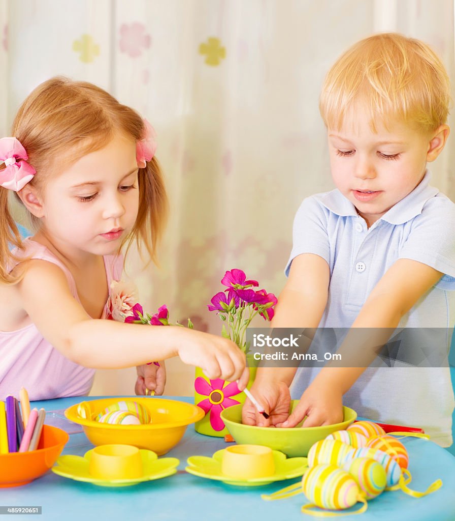 Kids paint Easter eggs Two serious children paint Easter eggs at home, using colorful decoration, Christian holiday concept Animal Egg Stock Photo