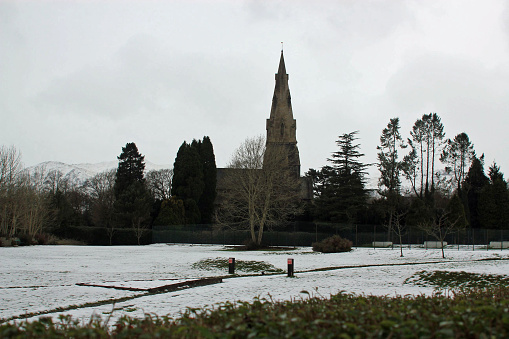 Church in Chester, UK on a Winter day with snow on the ground and grey clouds