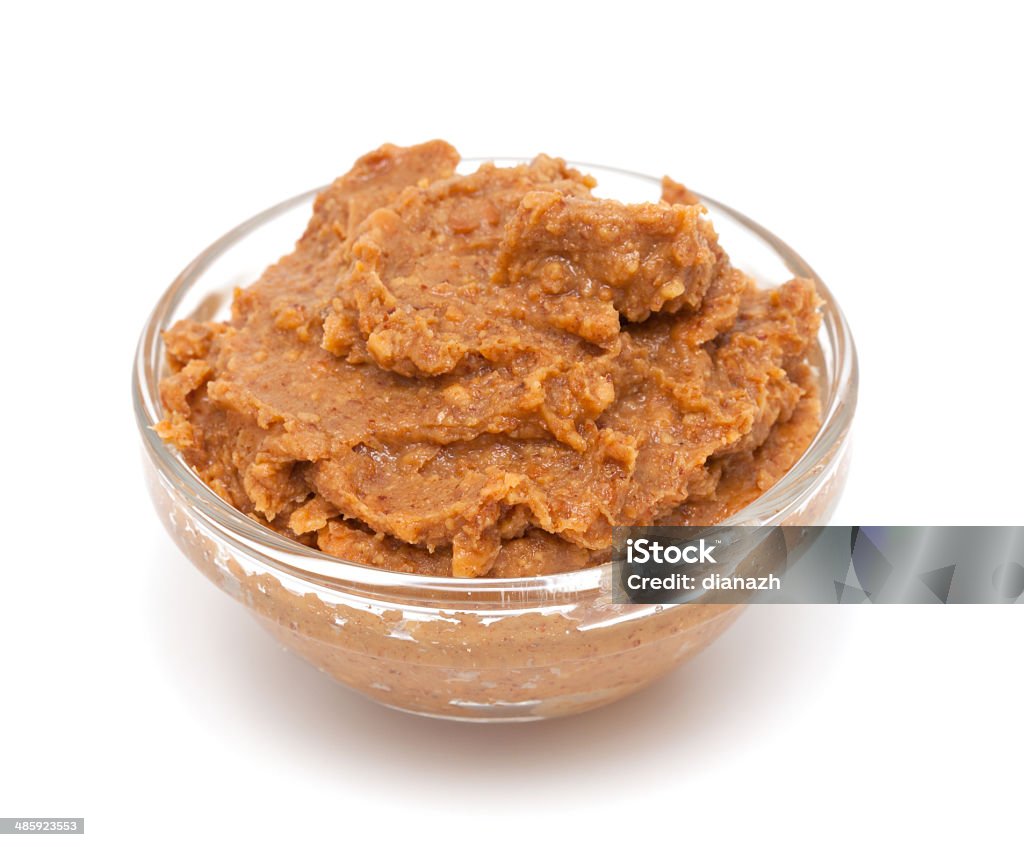 peanut butter crunchy peanut butter in a bowl over white Appetizer Stock Photo