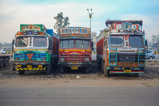 Mumbai, India - February 5, 2015: Parked trucks on highway rest area decorated in traditional Indian style.