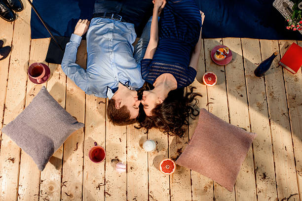 istock couple lying on wood floor with pillows and sweets 485923945