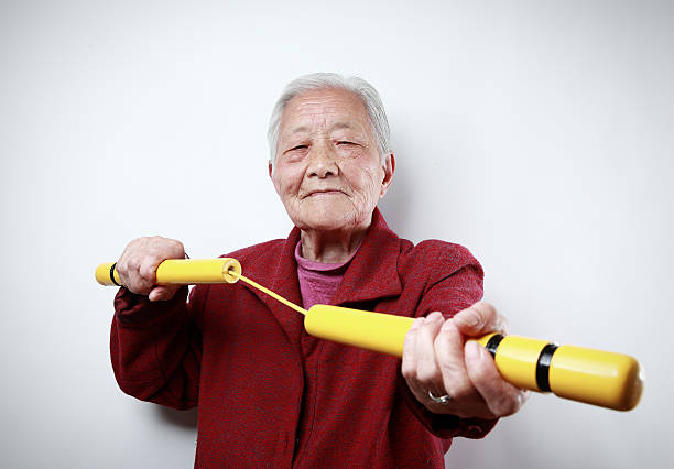 o antigo avó jogando nunchaku - nunchaku imagens e fotografias de stock