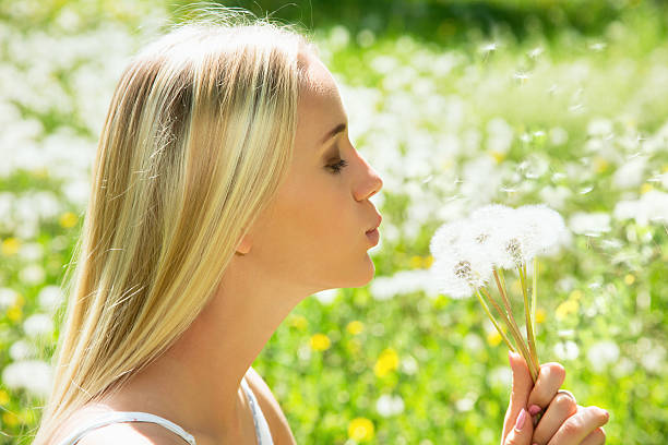 istock Girl blowing on white dandelion 485928444
