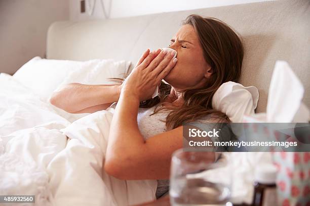 Woman Suffering From Cold Lying In Bed With Tissue Stock Photo - Download Image Now - 2015, 30-39 Years, Adult