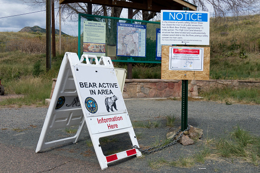 Denver, Colorado, USA - August 27, 2015: With numerous black bear sightings in the canyon which is frequented by fishermen, bicyclists, hikers and runners, multiple warning signs at the Waterton Canyon entrance give visitors notice that bears are active in area and warn not to approach and restrict fishing areas along the river.