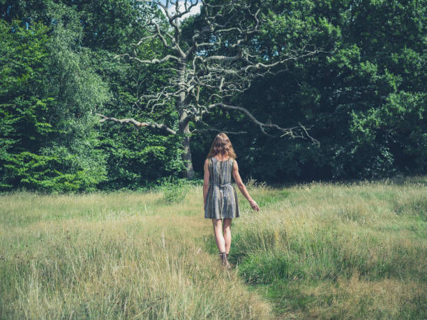 istock Young woman walking in meadow 485934510
