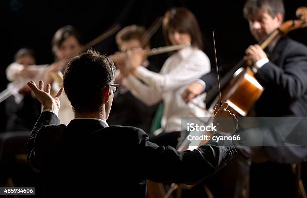 Conductor Directing Symphony Orchestra Stock Photo - Download Image Now - Musical Conductor, Orchestra, Classical Music