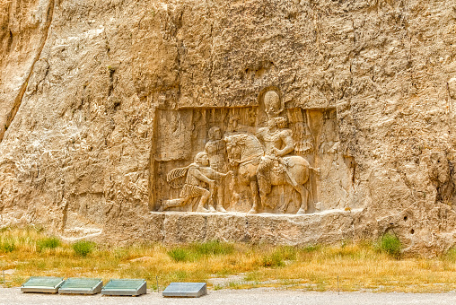 Ancient relief of the necropolis Naqsh-e Rustam that shows the triumph of Shapur I over the Roman Emperor Valerian and Philip the Arab, near ruins of Persepolis.