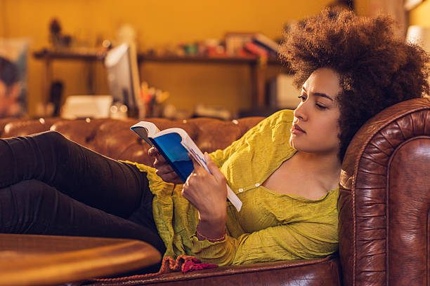 istock African American woman enjoying while reading a book at home. 485943568