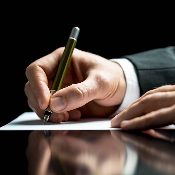 istock Businessman writing on a sheet of white paper 485943611