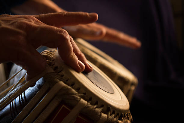 Hands Play Bongos Hands play bongos.  Dramatic lighting.   percussion instrument stock pictures, royalty-free photos & images