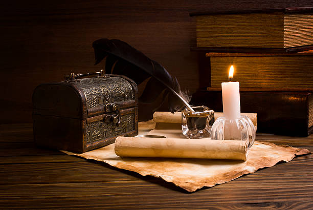 istock feather, old paper and candle on a wooden background 485944625