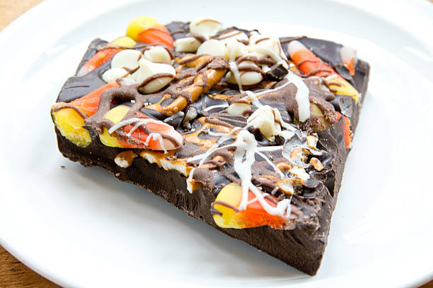 Halloween chocolate bark This chocolate bark treat contains candy corn, pretzels, and white chocolate chips and is served on a white plate. chocolate white chocolate chocolate chip white stock pictures, royalty-free photos & images