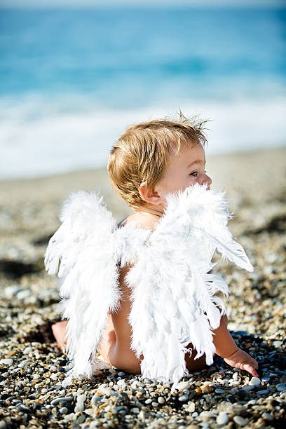 Cute boy sitting on the beach stock photo