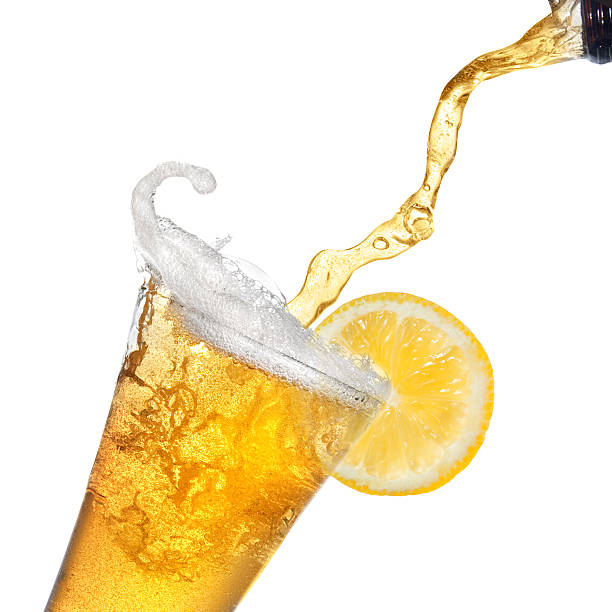 istock Beer pouring from bottle into glass with lemon isolated 485946673