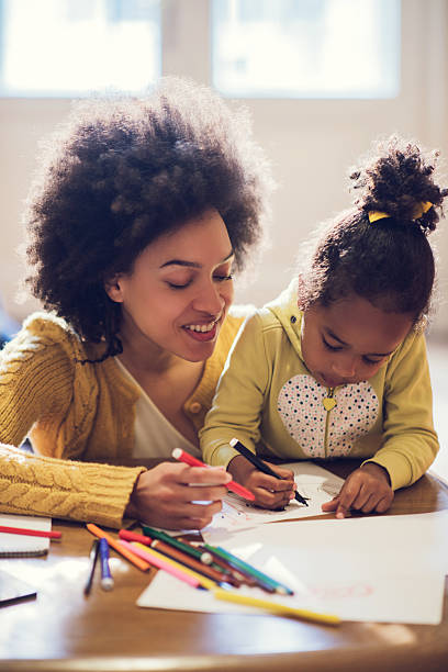 istock African American mother and daughter enjoying while coloring tog 485963410