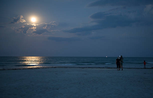 Moonrise in Cocoa Beach Florida Cape Canaveral, Florida, USA - May 24, 2013: People use a smartphone to photograph the moon and sea at Jetty Park in Cape Canaveral, Florida cocoa beach photos stock pictures, royalty-free photos & images