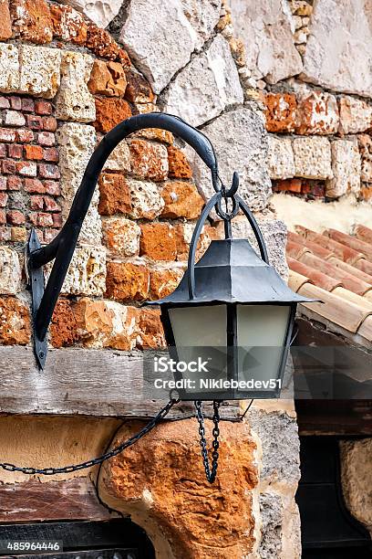 The Old Lantern Hanging On A Brick Wall Background Stock Photo - Download Image Now