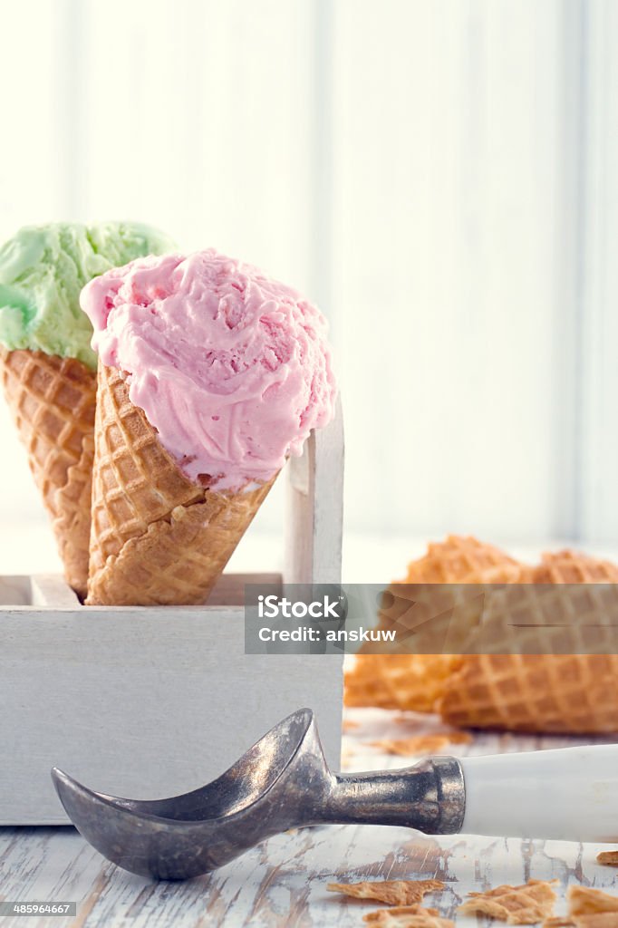 Ice cream cones with an old metal scoop Pink and green ice cream cones with an old metal scoop on wooden rustic background with vintage hazy editing Backgrounds Stock Photo