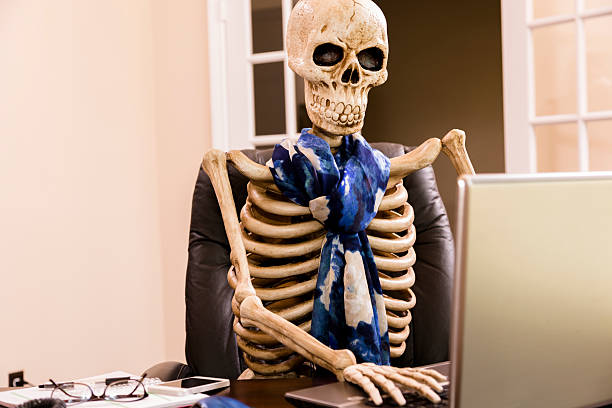 istock Working to death.  Business woman's skeleton using laptop in office. 485964785