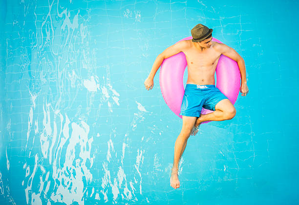 gut aussehender mann in einem swimmingpool - men sensuality photography high angle view stock-fotos und bilder