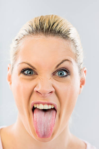 istock Woman sticking out tongue and looking at camera. 485965732