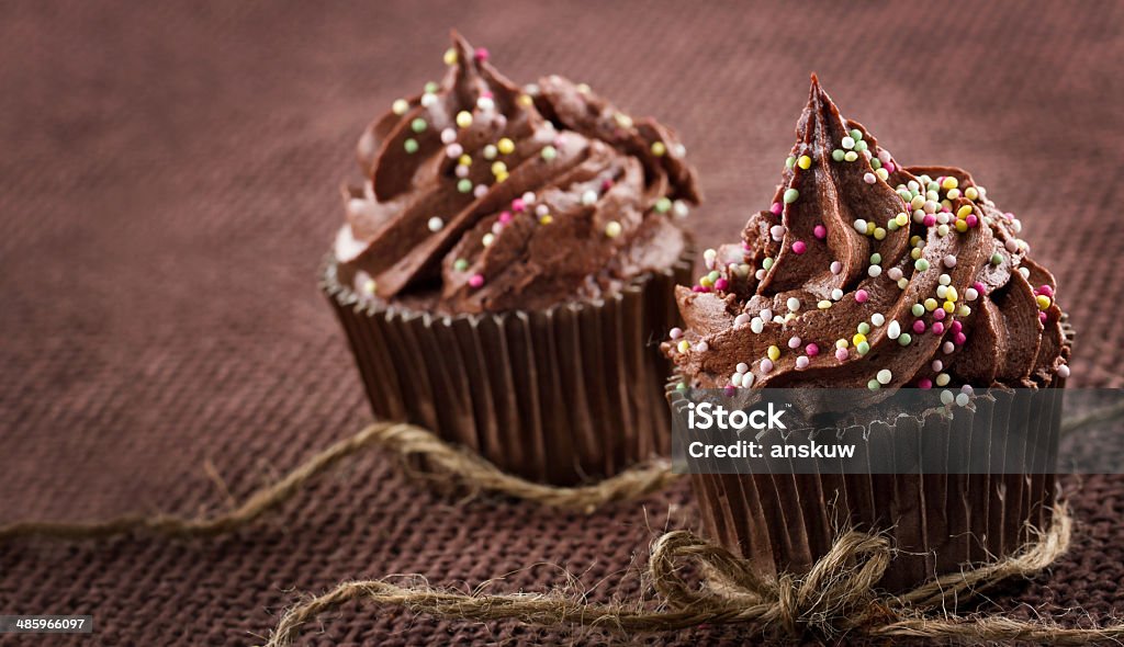 Homemade chocolate cupcakes Chocolate cupcake with colorful sprinkles on dark background and copy space Baked Stock Photo