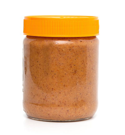 closed jar of peanut butter over white