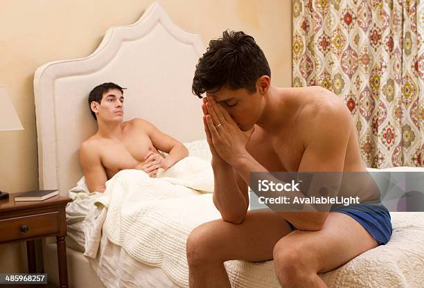 Gay Men Im Bett Bekämpfung Mann Prays Stockfoto und mehr Bilder von Bestürzt - Bestürzt, Bett, Beziehungsproblem