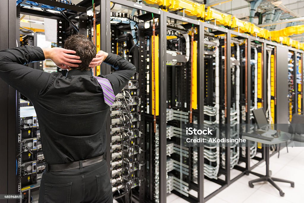 Trouble in data center Man looking astonished in a network data center. Data Center Stock Photo