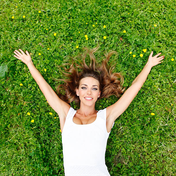 istock young woman in white dress lying on grass 485969820