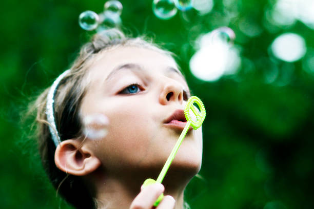 istock Young blond girl blowing bubbles outdoors 485970287