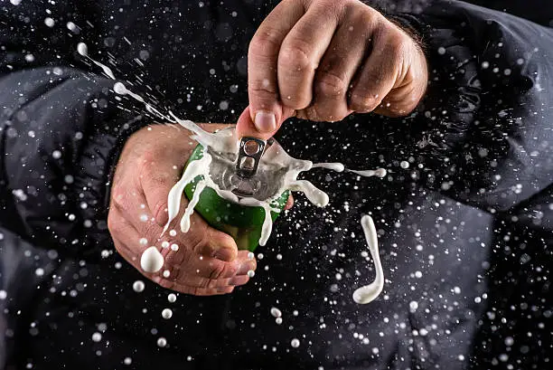 Photo of Frothy foam splashing out of a tin can