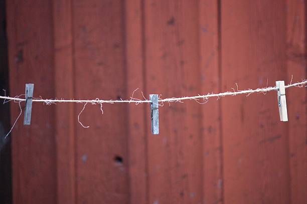 Hanging together - Close-up of a mini wooden clothespin or cloth peg hanging on string to hang art piece Wooden clothespin