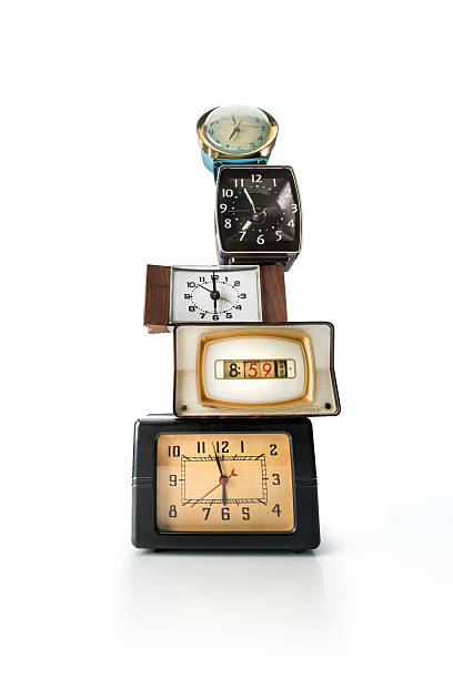 A tower of 5 vintage alarm clocks stacked on top of each other.
