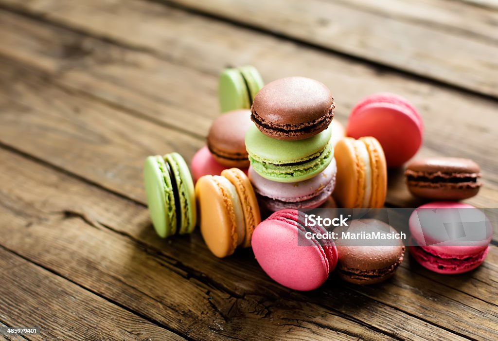 traditional french colorful macarons A lot of french colorful macarons on a woody floor Macaroon Stock Photo