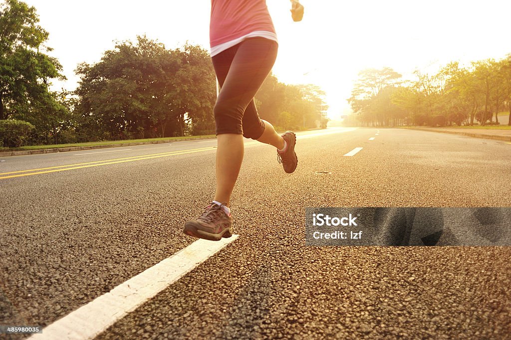 Sportswoman running along driveway healthy lifestyle fitness sports woman  running at sunrise driveway Active Lifestyle Stock Photo