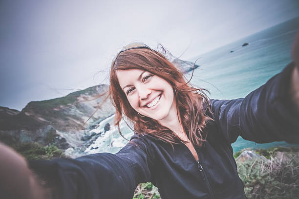 istock Happy Young Woman Taking Selfie at Famous Pacific Coast Highway 485982008