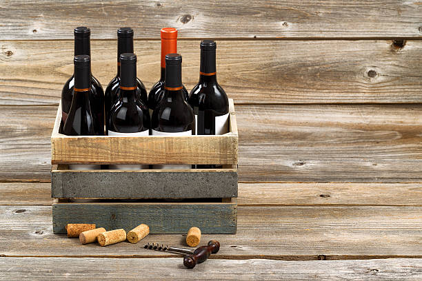 garrafas de vinho em caixa de madeira vermelho sobre tábuas de madeira - wine wine bottle box crate imagens e fotografias de stock